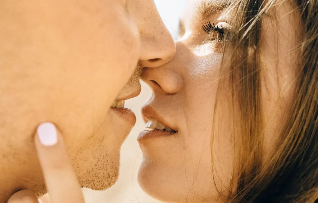 Un couple échange un baiser tendre sur les lèvres